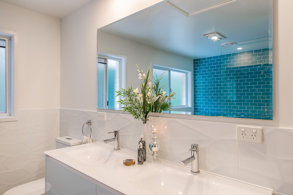 Großes Modernes Badezimmer mit verzierten Schränken, weißen Schränken, freistehender Badewanne, offener Dusche, Toilette mit Aufsatzspülkasten, blauen Fliesen, Keramikfliesen, blauer Wandfarbe, Keramikboden, Unterbauwaschbecken, Glaswaschbecken/Glaswaschtisch, grauem Boden, offener Dusche und weißer Waschtischplatte in Brisbane