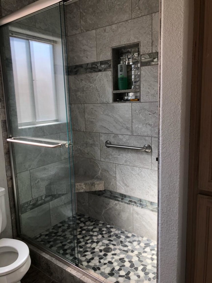 На фото: ванная комната среднего размера в стиле неоклассика (современная классика) с душем в нише, серой плиткой, керамогранитной плиткой, полом из галечной плитки, разноцветным полом и душем с раздвижными дверями с