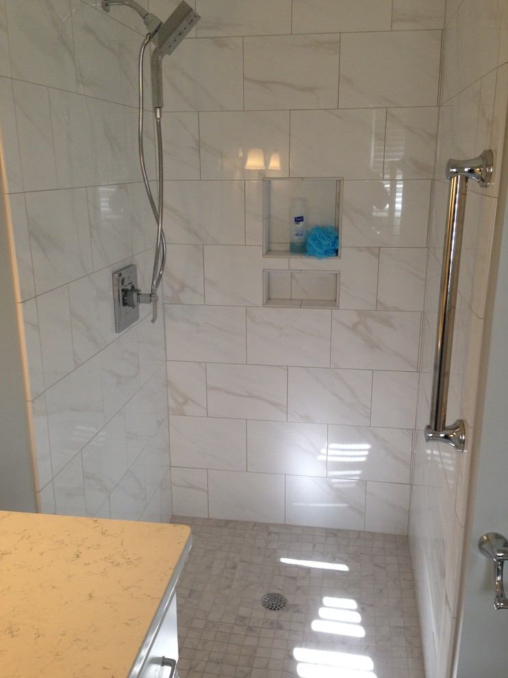 Inredning av ett klassiskt litet vit vitt en-suite badrum, med ett undermonterad handfat, luckor med infälld panel, vita skåp, bänkskiva i kvarts, en kantlös dusch, vit kakel, porslinskakel, grå väggar, klinkergolv i porslin, vitt golv och med dusch som är öppen
