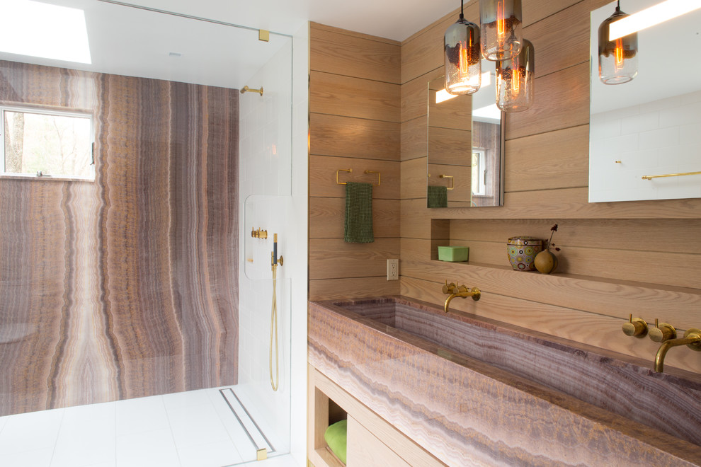 Example of a mid-sized minimalist master brown tile, multicolored tile and stone slab alcove shower design in New York with a trough sink, a hinged shower door, brown countertops and onyx countertops