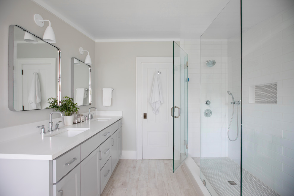 Esempio di una stanza da bagno minimal con vasca freestanding, doccia ad angolo, lavabo sottopiano, porta doccia a battente e top bianco