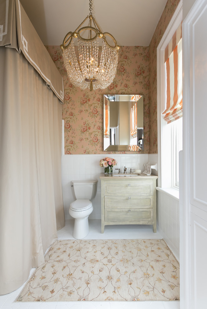 Inredning av ett klassiskt badrum, med ett undermonterad handfat, skåp i slitet trä, en toalettstol med separat cisternkåpa, flerfärgade väggar och skåp i shakerstil