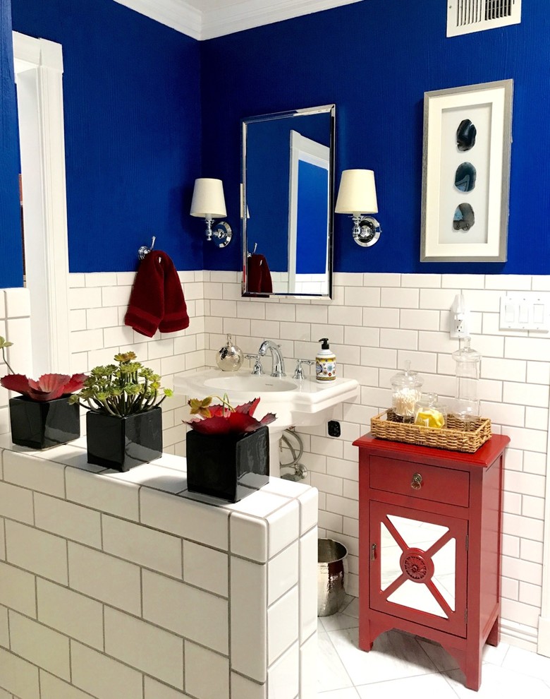 На фото: ванная комната среднего размера в стиле неоклассика (современная классика) с стеклянными фасадами, красными фасадами, ванной в нише, душем над ванной, белой плиткой, плиткой кабанчик, синими стенами, полом из керамической плитки, душевой кабиной, раковиной с пьедесталом, столешницей из искусственного камня, белым полом и шторкой для ванной с