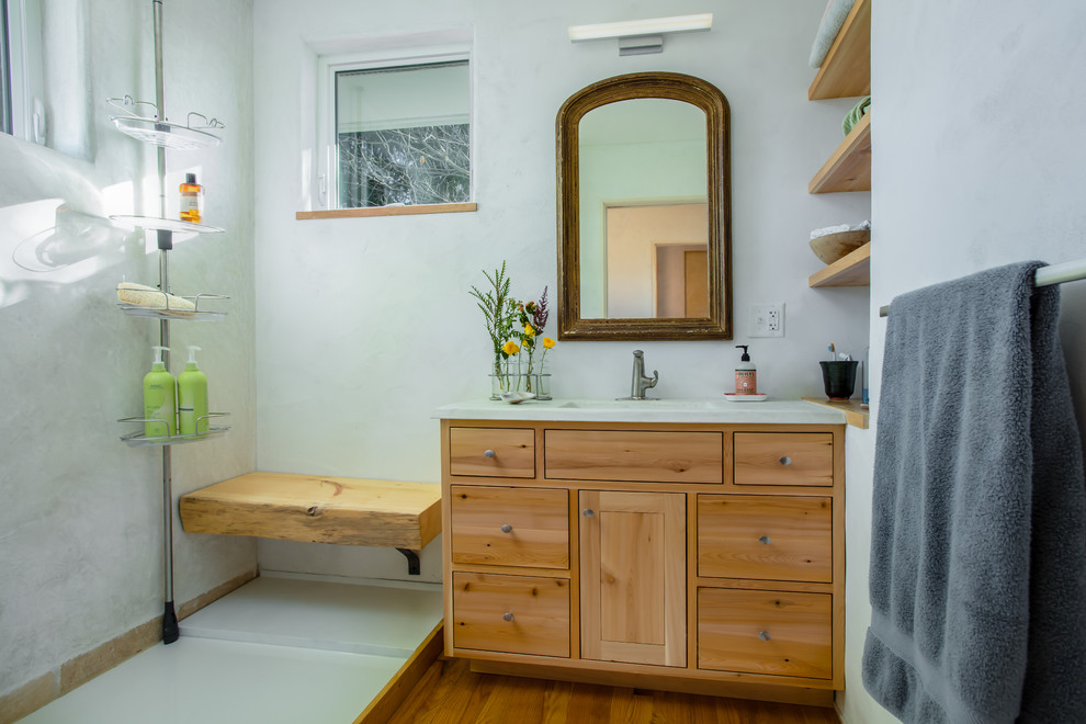 Cette photo montre une salle d'eau nature en bois brun avec un placard à porte plane, une douche ouverte, un mur blanc, un sol en bois brun, un lavabo intégré, un sol marron et aucune cabine.