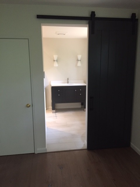 Photo of a medium sized midcentury ensuite bathroom in Other with recessed-panel cabinets, black cabinets, an alcove shower, a two-piece toilet, beige tiles, ceramic tiles, white walls, ceramic flooring, a submerged sink and quartz worktops.