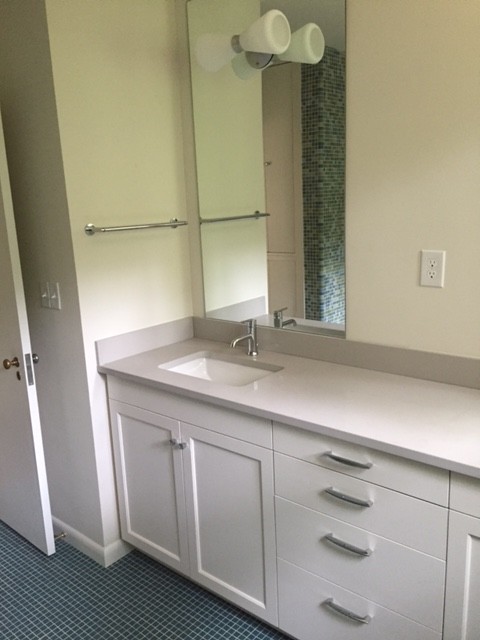 Example of a mid-sized 1950s kids' multicolored tile and ceramic tile ceramic tile bathroom design in Other with recessed-panel cabinets, white cabinets, a two-piece toilet, white walls, an undermount sink and quartzite countertops