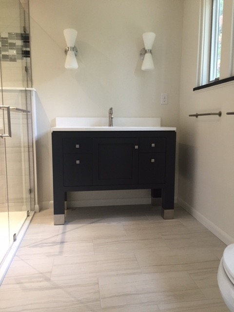 Alcove shower - mid-sized 1960s master beige tile and ceramic tile ceramic tile alcove shower idea in Other with recessed-panel cabinets, black cabinets, a two-piece toilet, white walls, an undermount sink and quartzite countertops