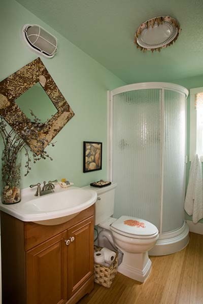 Kleines Eklektisches Duschbad mit Waschtischkonsole, profilierten Schrankfronten, hellen Holzschränken, Eckdusche, Wandtoilette mit Spülkasten, grüner Wandfarbe und Bambusparkett in Sonstige