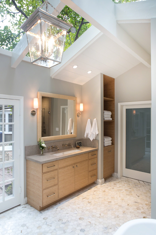 Example of a transitional master mosaic tile floor freestanding bathtub design in Los Angeles with gray walls, flat-panel cabinets, light wood cabinets and a trough sink