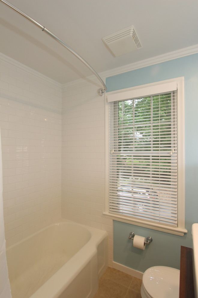 Photo of a medium sized classic ensuite bathroom in Grand Rapids with a vessel sink, beaded cabinets, white cabinets, wooden worktops, an alcove bath, a shower/bath combination, a one-piece toilet, white tiles, metro tiles, blue walls and ceramic flooring.
