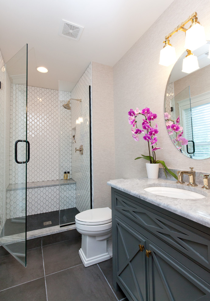 Photo of a small country shower room bathroom in Chicago with grey cabinets, a two-piece toilet, beige walls, ceramic flooring, a submerged sink, onyx worktops, brown floors, a hinged door, grey worktops, freestanding cabinets, an alcove shower, white tiles, ceramic tiles, a shower bench, a freestanding vanity unit, wallpapered walls and a single sink.