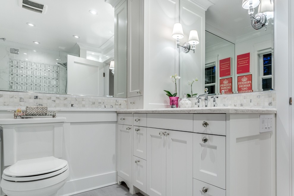 Design ideas for a medium sized traditional ensuite bathroom in Vancouver with shaker cabinets, white cabinets, an alcove shower, a one-piece toilet, white tiles, stone tiles, white walls, porcelain flooring, a submerged sink and engineered stone worktops.