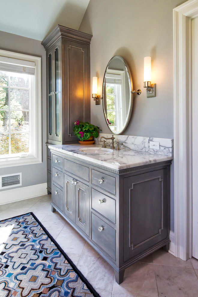 Example of a classic master marble floor freestanding bathtub design in New York with marble countertops, gray cabinets, beaded inset cabinets, gray walls and white countertops