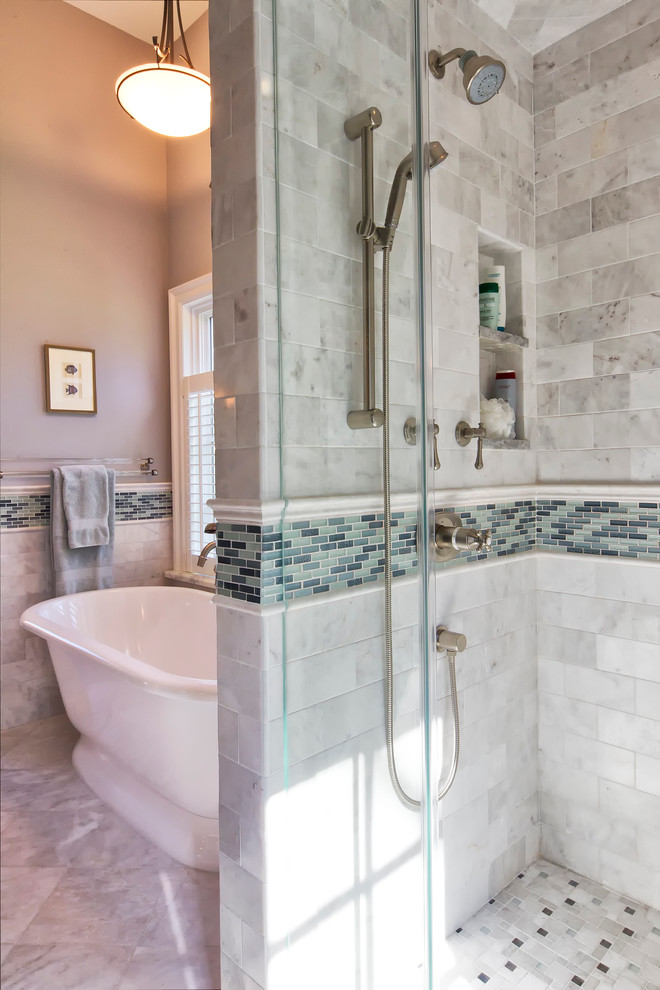 Idéer för att renovera ett vintage vit vitt badrum, med luckor med profilerade fronter, skåp i slitet trä, ett fristående badkar, en dusch i en alkov, en toalettstol med hel cisternkåpa, grå kakel, marmorkakel, grå väggar, marmorgolv, ett undermonterad handfat, marmorbänkskiva, grått golv och dusch med gångjärnsdörr