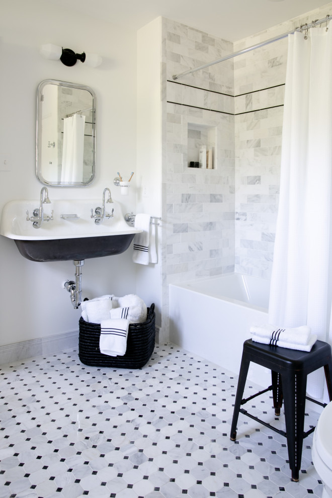 Photo of a small traditional family bathroom in New York with an alcove bath, a shower/bath combination, white tiles, marble tiles, white walls, marble flooring, a trough sink, white floors, a shower curtain, double sinks and a wall niche.