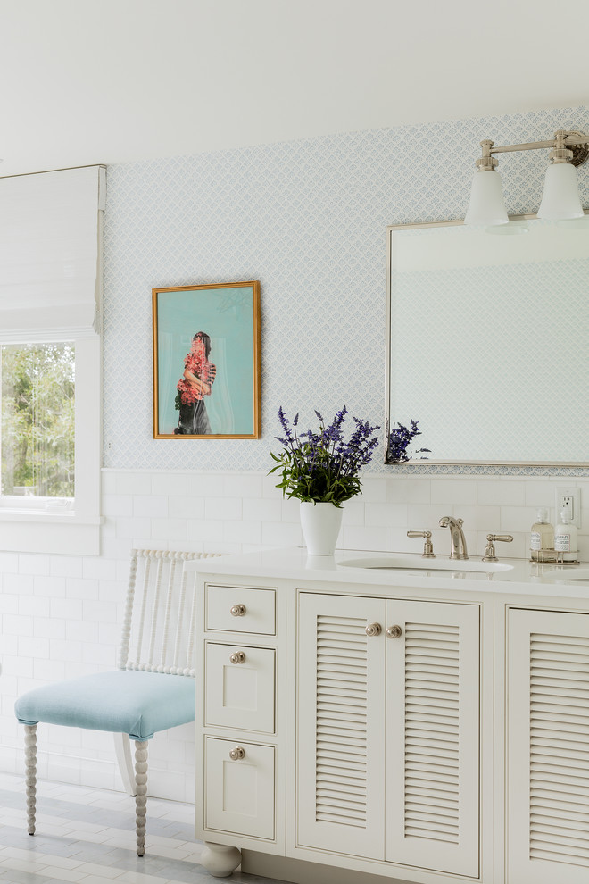 На фото: ванная комната в классическом стиле с фасадами с филенкой типа жалюзи, белыми фасадами, белой плиткой, синими стенами и врезной раковиной с