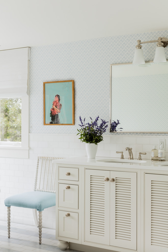 Elegant white tile bathroom photo in San Francisco with louvered cabinets, white cabinets, blue walls and an undermount sink