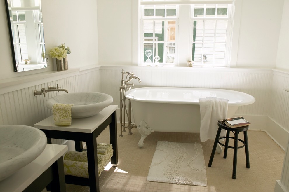 Inredning av ett klassiskt litet en-suite badrum, med ett fristående handfat, öppna hyllor, skåp i mörkt trä, bänkskiva i kvarts, ett badkar med tassar, beige kakel, keramikplattor, vita väggar och klinkergolv i keramik