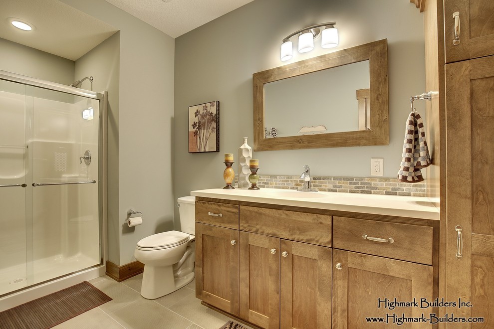 Bild på ett mellanstort vintage badrum med dusch, med ett integrerad handfat, skåp i shakerstil, skåp i ljust trä, bänkskiva i akrylsten, en dusch i en alkov, en toalettstol med separat cisternkåpa, blå kakel, porslinskakel, blå väggar och klinkergolv i keramik
