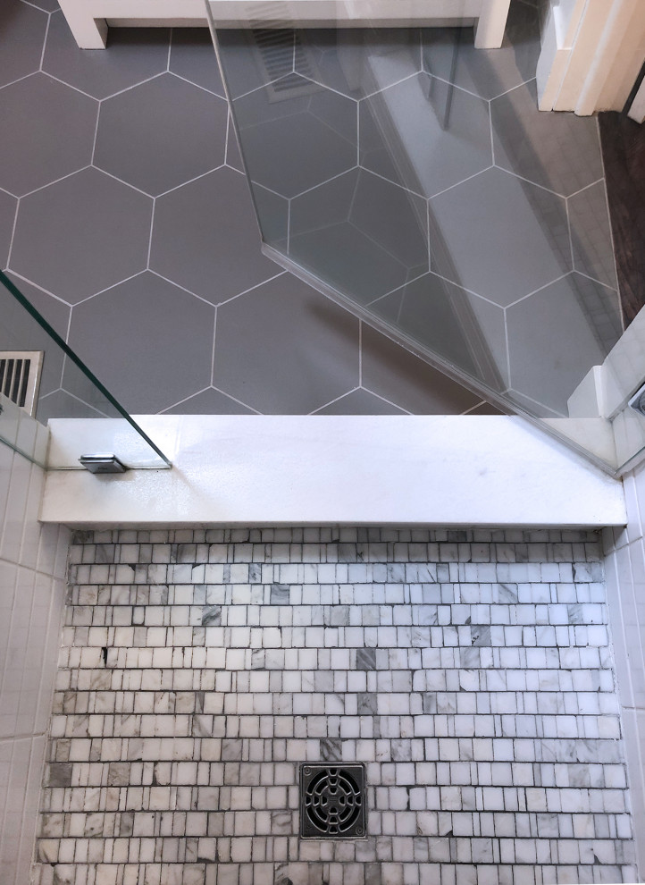 Пример оригинального дизайна: маленькая главная ванная комната в стиле неоклассика (современная классика) с фасадами в стиле шейкер, серыми фасадами, душем в нише, унитазом-моноблоком, белой плиткой, керамической плиткой, белыми стенами, полом из мозаичной плитки, врезной раковиной, мраморной столешницей, разноцветным полом, душем с распашными дверями, серой столешницей, тумбой под одну раковину, напольной тумбой и сводчатым потолком для на участке и в саду