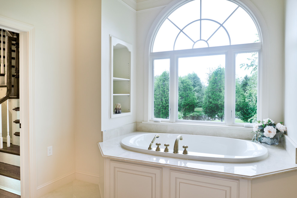 Пример оригинального дизайна: главная ванная комната среднего размера в стиле модернизм с белыми фасадами, гидромассажной ванной, двойным душем, унитазом-моноблоком, белой плиткой, белыми стенами, мраморным полом, врезной раковиной, бежевым полом, душем с распашными дверями и бежевой столешницей
