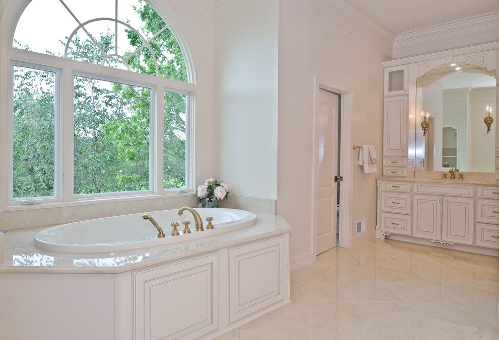 Aménagement d'une salle de bain principale moderne de taille moyenne avec des portes de placard blanches, un bain bouillonnant, une douche double, WC à poser, un carrelage blanc, un mur blanc, un sol en marbre, un lavabo encastré, un sol beige, une cabine de douche à porte battante et un plan de toilette beige.
