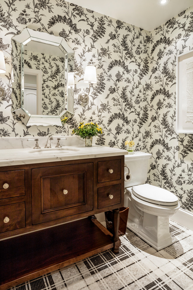 Cette image montre une salle d'eau traditionnelle en bois brun de taille moyenne avec un placard en trompe-l'oeil, WC à poser, un plan de toilette en marbre, un sol noir, un sol en marbre, un lavabo encastré et un plan de toilette blanc.