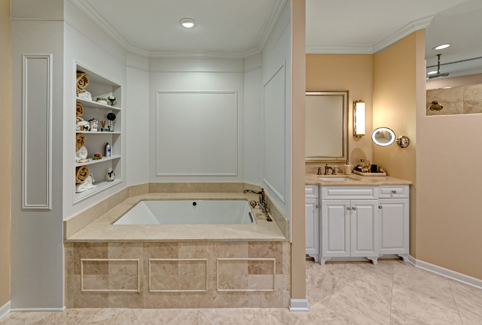 This is an example of a large traditional ensuite bathroom in Minneapolis with freestanding cabinets, white cabinets, a submerged bath, a walk-in shower, a two-piece toilet, beige tiles, stone tiles, beige walls, travertine flooring, a submerged sink and limestone worktops.