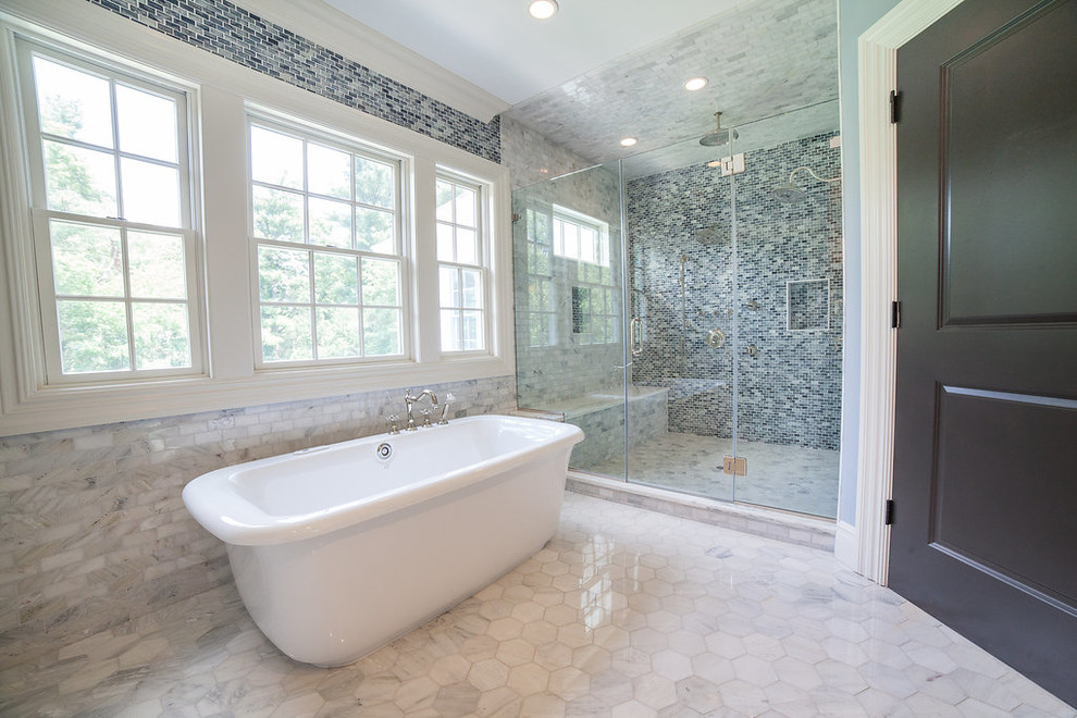 Стильный дизайн: большая главная ванная комната в стиле неоклассика (современная классика) с отдельно стоящей ванной, душем в нише, черно-белой плиткой, синей плиткой, каменной плиткой, синими стенами и мраморным полом - последний тренд