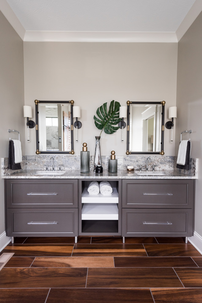 Klassisk inredning av ett mellanstort grå grått en-suite badrum, med skåp i shakerstil, grå skåp, grå väggar, ett undermonterad handfat, mellanmörkt trägolv, ett fristående badkar, våtrum, beige kakel, keramikplattor, granitbänkskiva och dusch med gångjärnsdörr