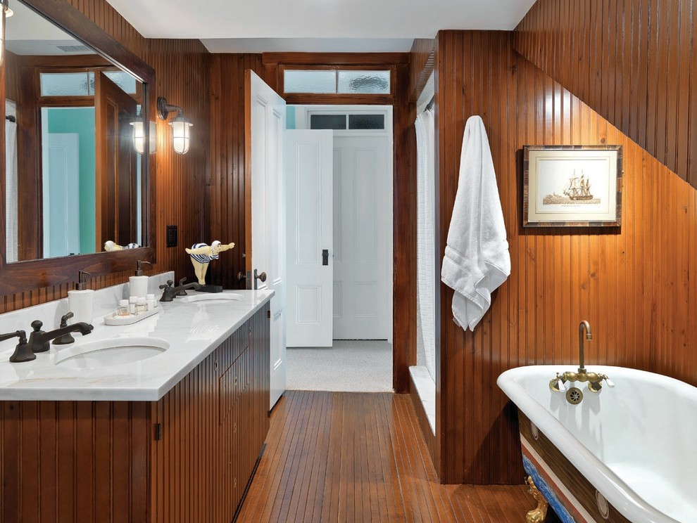 Idéer för stora maritima vitt badrum med dusch, med ett undermonterad handfat, skåp i mellenmörkt trä, ett badkar med tassar, en dusch i en alkov, bruna väggar, marmorbänkskiva och släta luckor