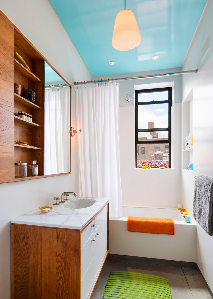 Inspiration för ett funkis badrum för barn, med ett badkar i en alkov, marmorbänkskiva, släta luckor, vita skåp, en dusch/badkar-kombination, vita väggar, ett undermonterad handfat och dusch med duschdraperi
