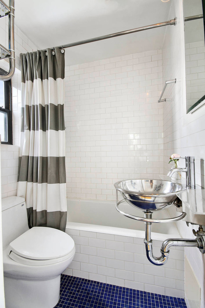 Пример оригинального дизайна: маленькая ванная комната в современном стиле с подвесной раковиной, душем над ванной, унитазом-моноблоком, белой плиткой, белыми стенами, полом из мозаичной плитки, ванной в нише, плиткой кабанчик, стеклянной столешницей, синим полом и шторкой для ванной для на участке и в саду