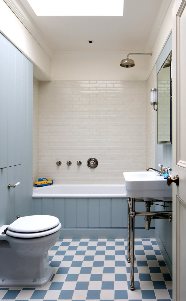 Réalisation d'une salle de bain tradition pour enfant avec une baignoire posée, un combiné douche/baignoire, un carrelage blanc, des carreaux de céramique et un mur bleu.