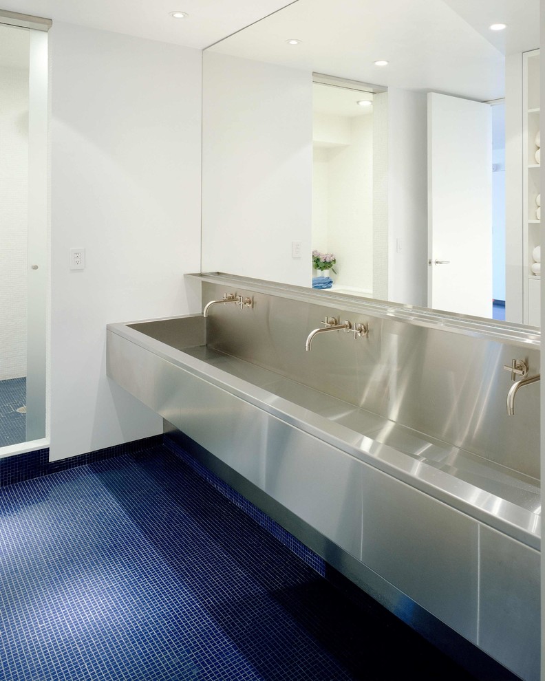 Пример оригинального дизайна: ванная комната в современном стиле с плоскими фасадами, белыми стенами, полом из керамической плитки, монолитной раковиной, столешницей из нержавеющей стали и синим полом