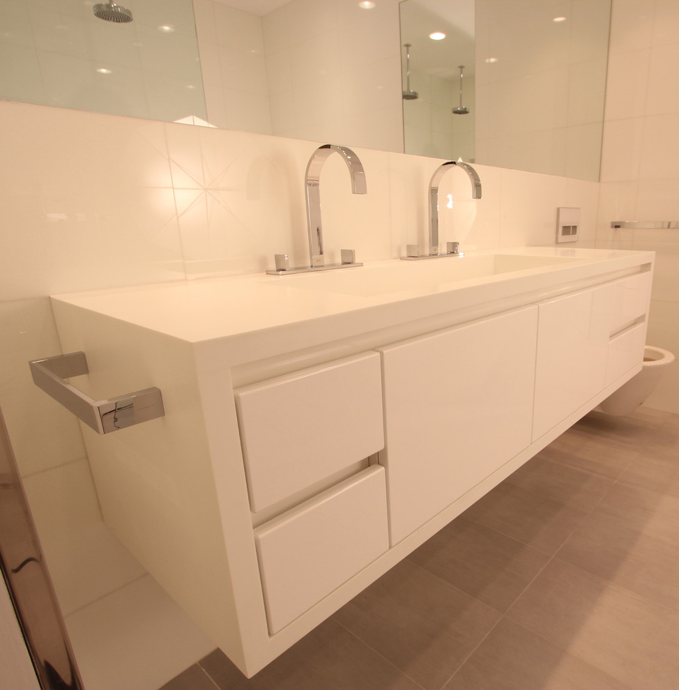 Mittelgroßes Modernes Badezimmer En Suite mit integriertem Waschbecken, flächenbündigen Schrankfronten, weißen Schränken, Badewanne in Nische, Duschbadewanne, Toilette mit Aufsatzspülkasten und weißer Wandfarbe in New York