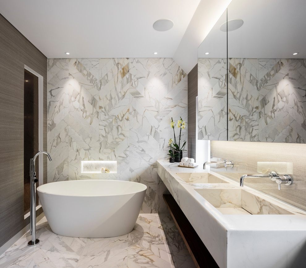 Foto på ett mellanstort funkis en-suite badrum, med skåp i mörkt trä, ett fristående badkar, stenkakel, marmorgolv, ett integrerad handfat, marmorbänkskiva, öppna hyllor och flerfärgad kakel