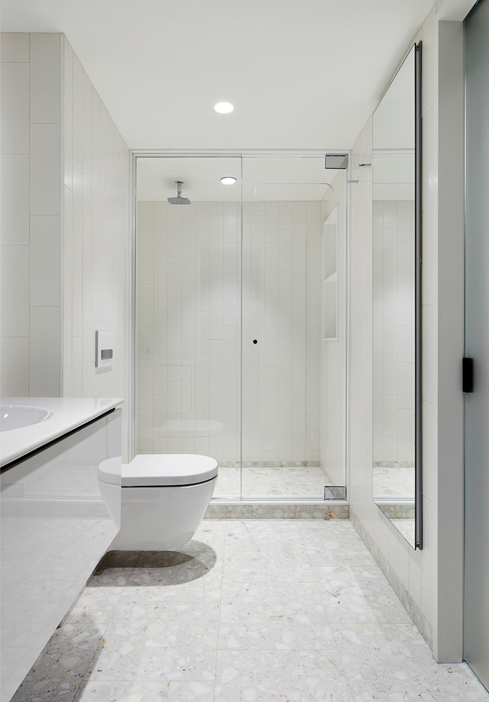 Идея дизайна: ванная комната среднего размера в современном стиле с плоскими фасадами, белыми фасадами, душем в нише, душевой кабиной, монолитной раковиной, столешницей из искусственного камня, белым полом, душем с распашными дверями, белой столешницей и белыми стенами
