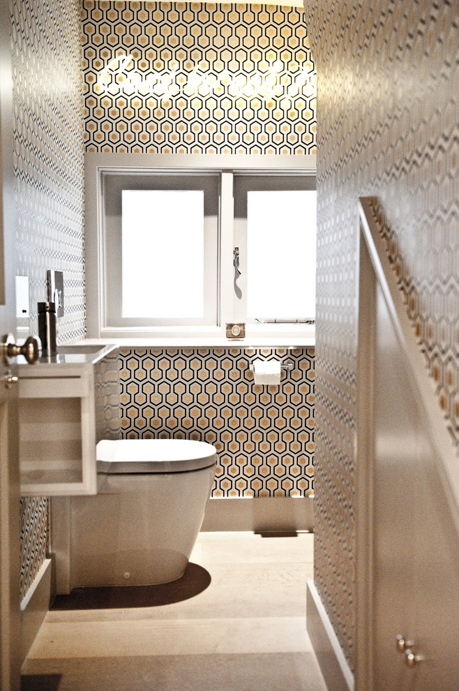 Modern inredning av ett litet badrum, med vita skåp, en toalettstol med hel cisternkåpa, grå kakel, stenkakel, flerfärgade väggar och ett väggmonterat handfat