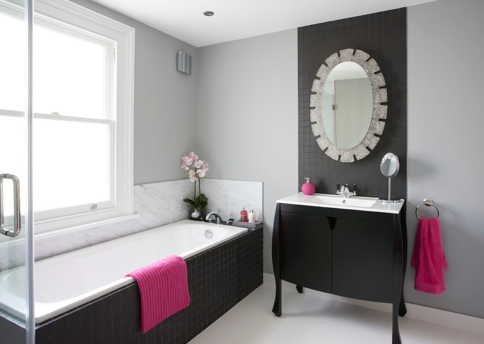 Diseño de cuarto de baño clásico renovado con sanitario de pared, paredes grises, suelo de baldosas de cerámica, lavabo bajoencimera, bañera encastrada, baldosas y/o azulejos negros y armarios con paneles lisos
