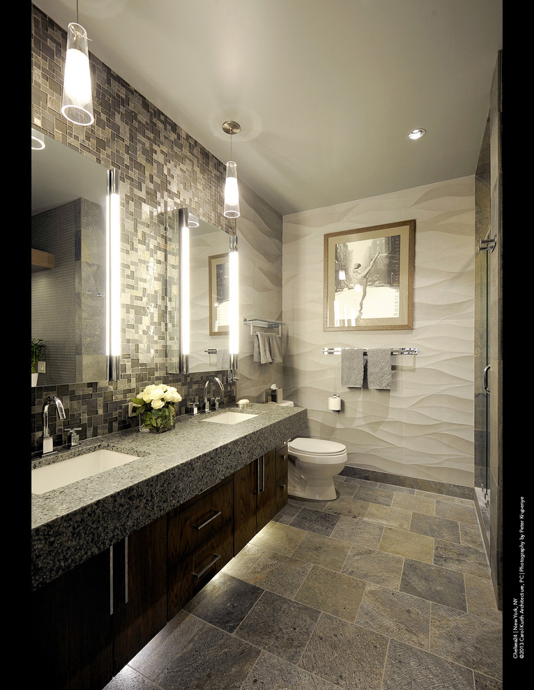 Design ideas for a modern ensuite bathroom in New York with a built-in sink, flat-panel cabinets, dark wood cabinets, a one-piece toilet, multi-coloured tiles, glass tiles and grey walls.