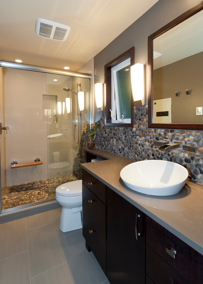 Cette photo montre une salle de bain chic en bois foncé avec une vasque, un placard à porte plane, un plan de toilette en quartz modifié, un carrelage beige, un carrelage de pierre, un mur beige et un sol en carrelage de porcelaine.