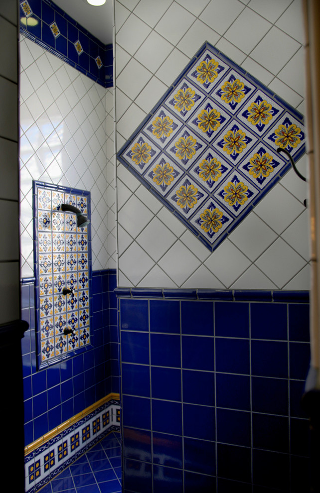 Aménagement d'une grande salle de bain principale méditerranéenne en bois foncé avec un placard avec porte à panneau surélevé, une baignoire encastrée, un carrelage bleu, des carreaux de céramique, un mur beige, tomettes au sol, un lavabo encastré, un plan de toilette en carrelage, un sol rouge et un plan de toilette orange.