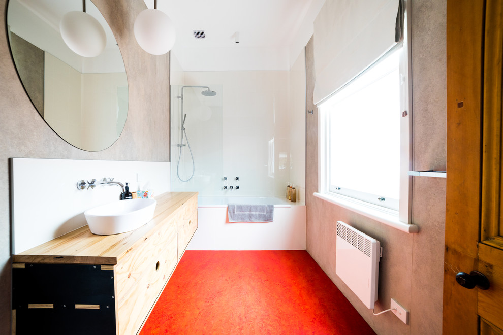 Diseño de cuarto de baño contemporáneo con combinación de ducha y bañera, paredes grises, suelo de linóleo, encimera de madera y suelo rojo