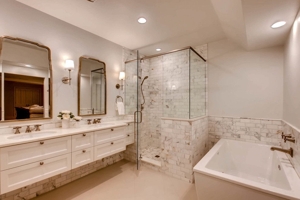 Large classic bathroom in Denver with recessed-panel cabinets, white cabinets, a freestanding bath, a corner shower, white tiles, grey walls, a submerged sink, grey floors, a hinged door and ceramic flooring.