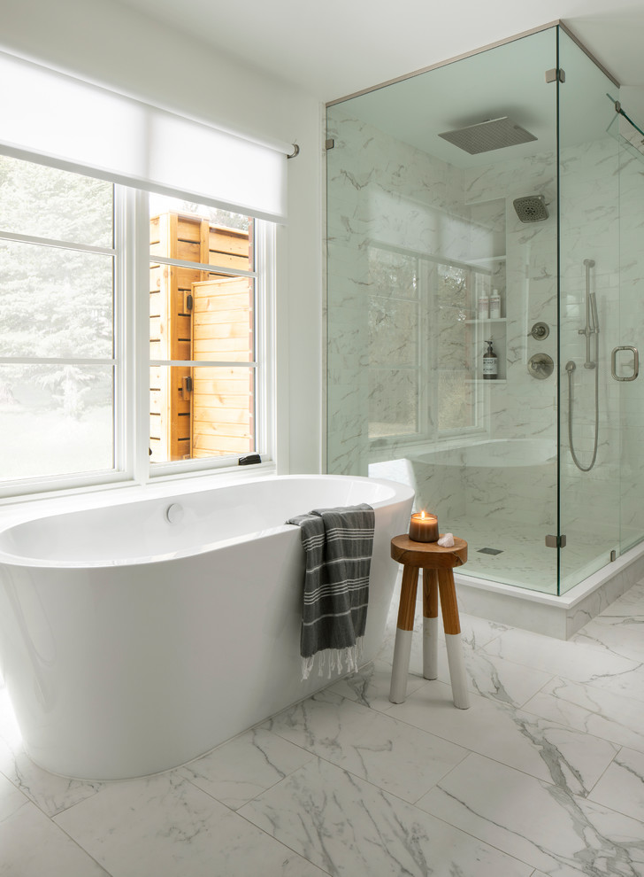 Inredning av ett skandinaviskt badrum, med ett fristående badkar, vit kakel, vita väggar och vitt golv