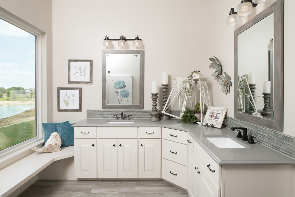 Immagine di una stanza da bagno padronale costiera di medie dimensioni con ante beige, piastrelle grigie, piastrelle di vetro, pareti beige, lavabo sottopiano e top in granito
