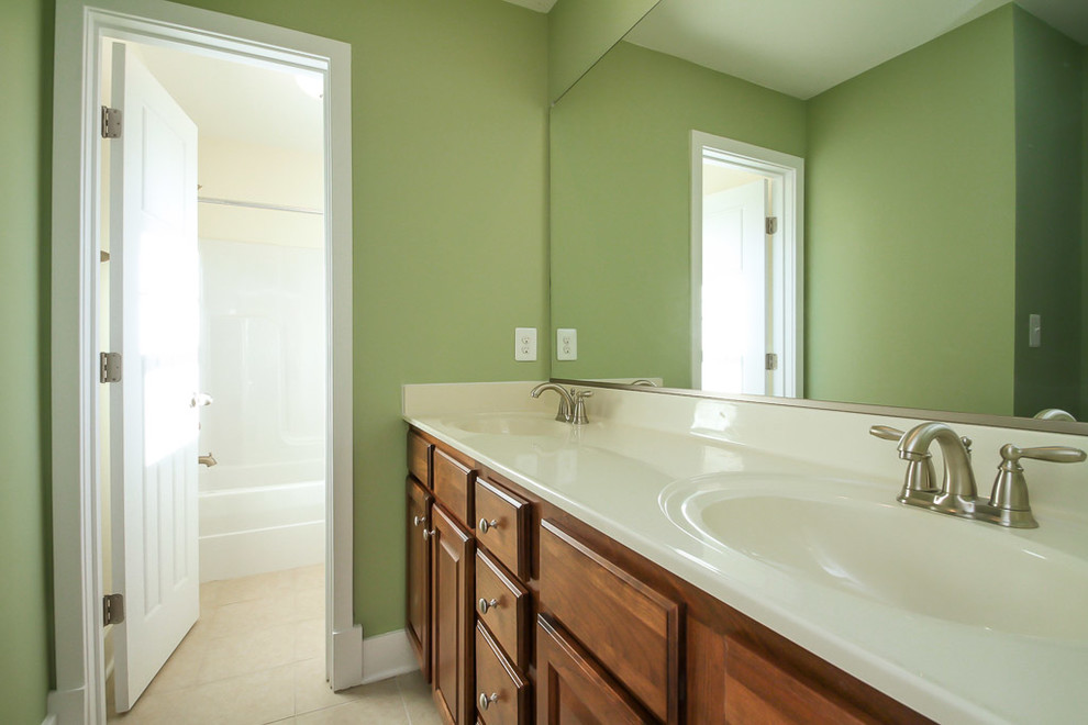 ワシントンD.C.にある小さなトラディショナルスタイルのおしゃれな浴室 (コンソール型シンク、茶色いキャビネット、ドロップイン型浴槽、シャワー付き浴槽	、一体型トイレ	、リノリウムの床) の写真
