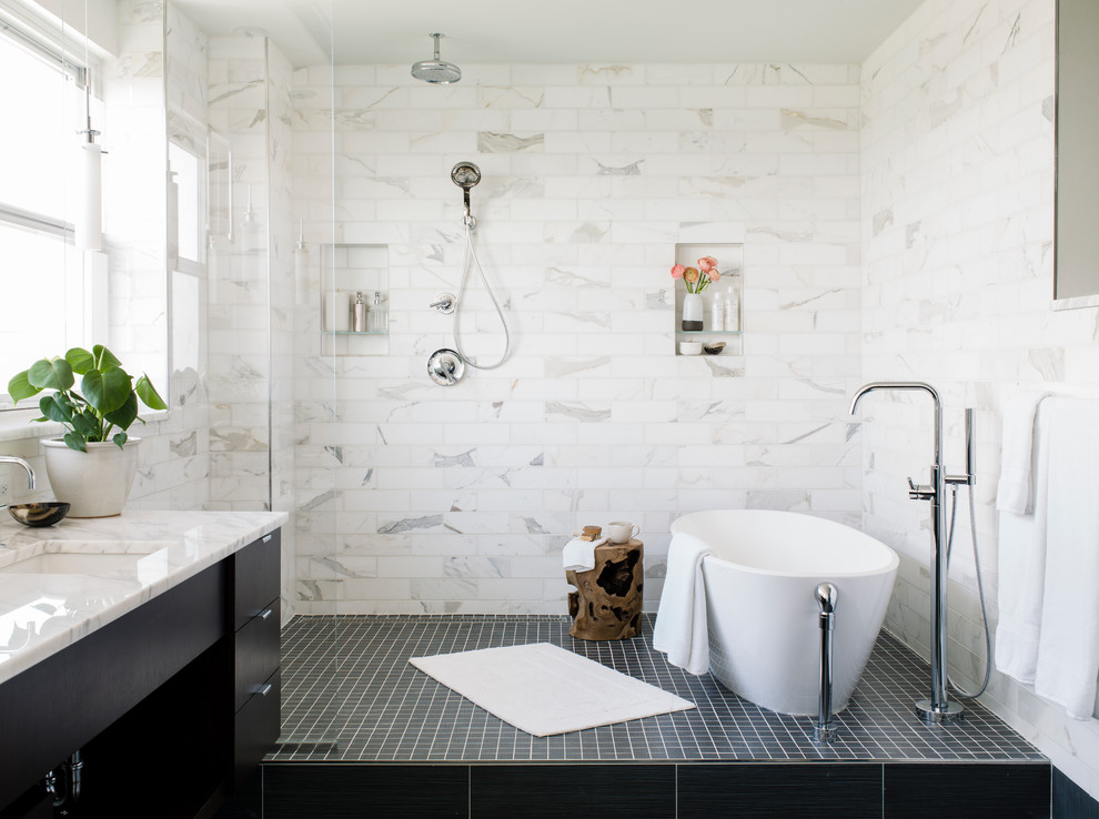 Aménagement d'une salle de bain principale contemporaine de taille moyenne avec un placard à porte plane, une douche à l'italienne, un carrelage blanc, du carrelage en marbre, un mur blanc, un sol en carrelage de porcelaine, un lavabo encastré, un plan de toilette en marbre, un sol noir, aucune cabine, un plan de toilette blanc, des portes de placard noires et une baignoire indépendante.