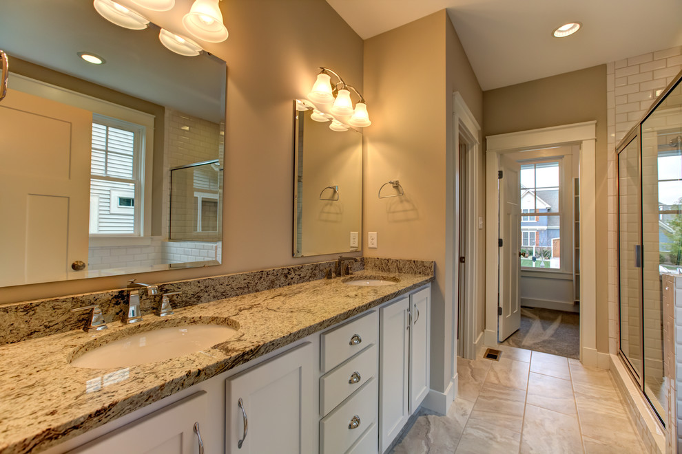 Immagine di una grande stanza da bagno padronale tradizionale con ante in stile shaker, ante bianche, pareti beige, lavabo sottopiano e top in granito